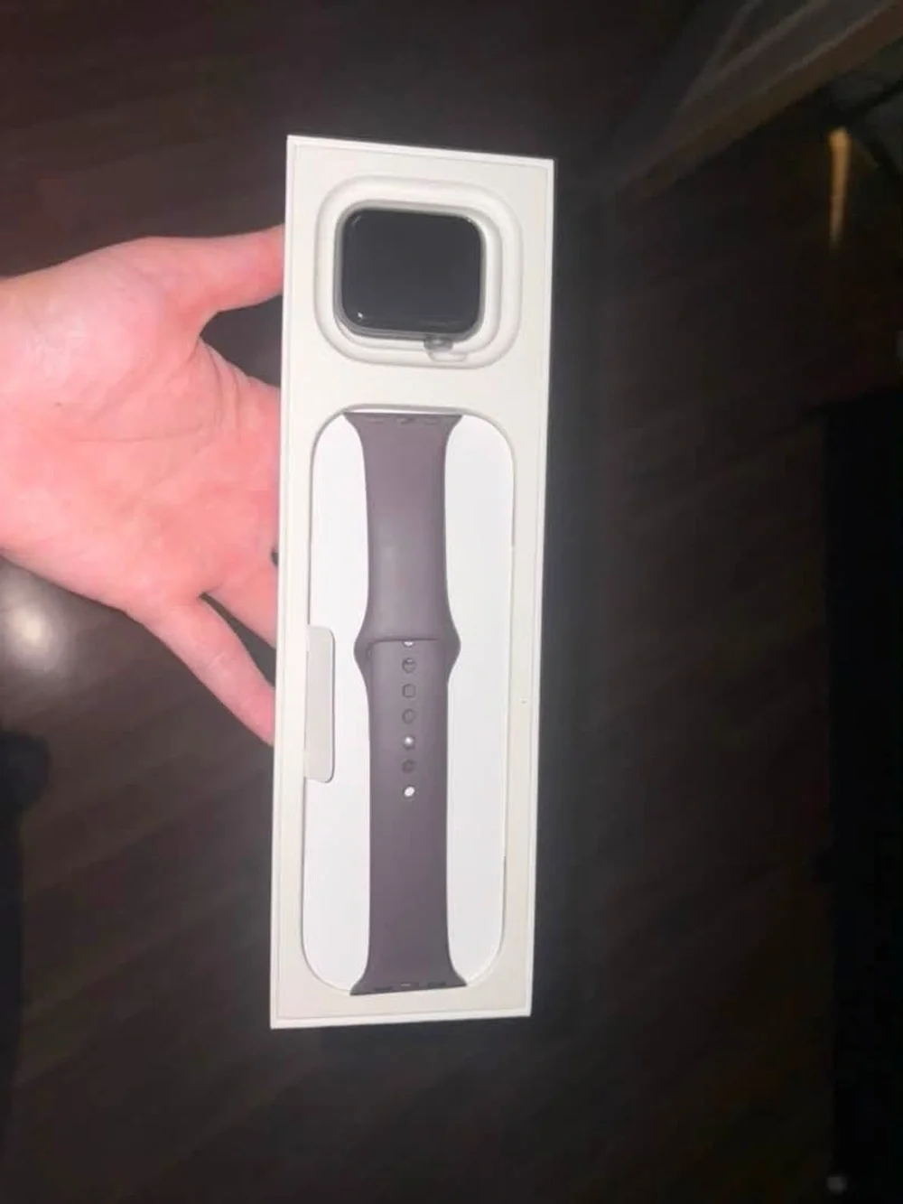 Apple SE GPS watch in grey aluminum case with maroon sports band.